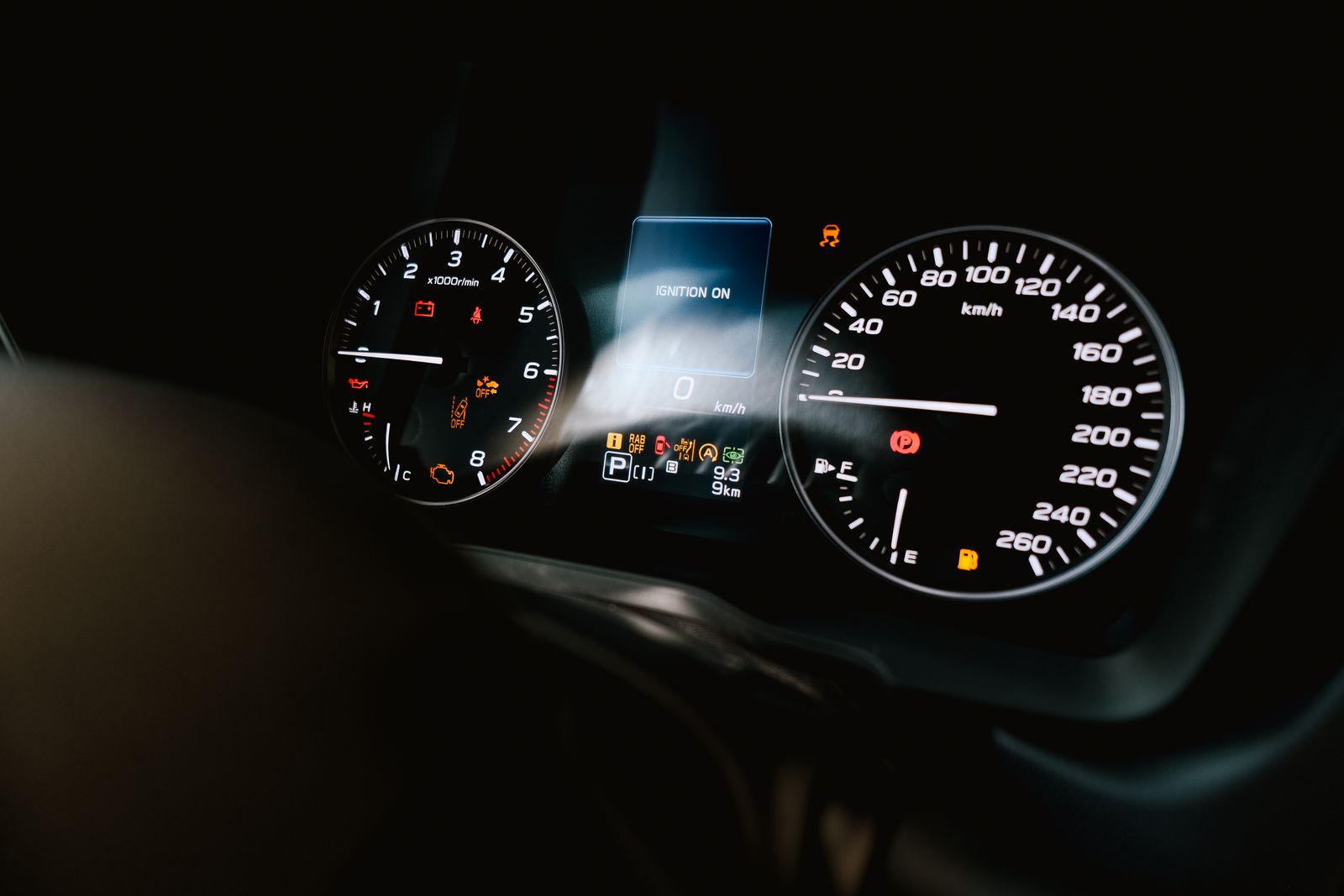 A vehicle dashboard displaying common warning light symbols